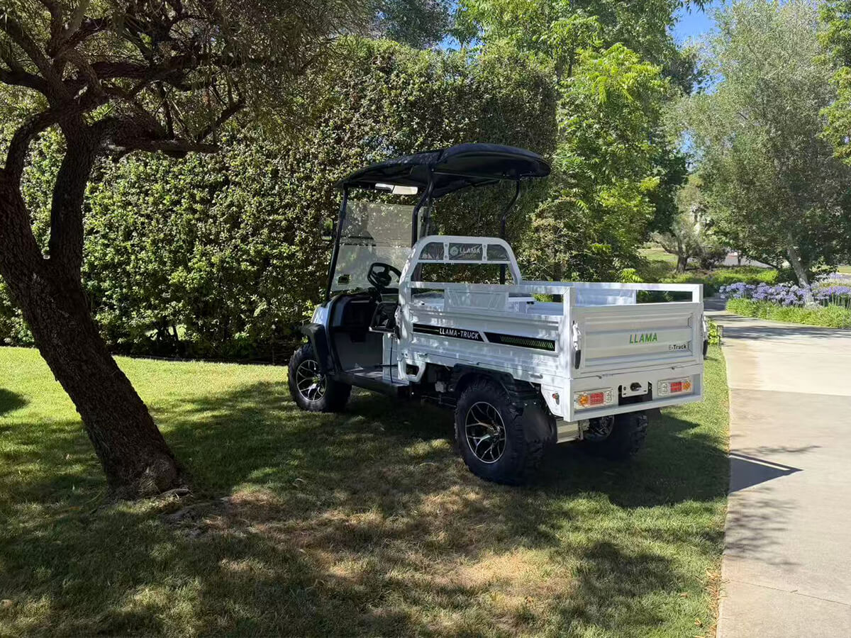 LLAMA Apex electric utility vehicle parked beneath a tree